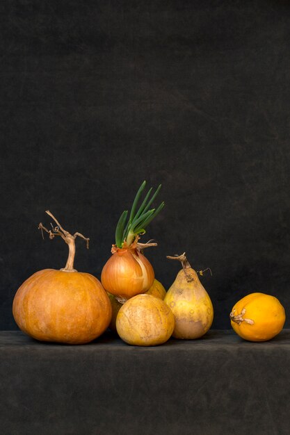 Still life with several pumpkins and sprouted onions