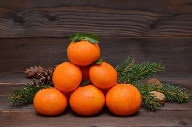 Still life with tangerines, fir branches and nuts in a rustic style