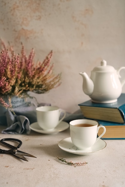 Foto natura morta con tè, libri e fiori