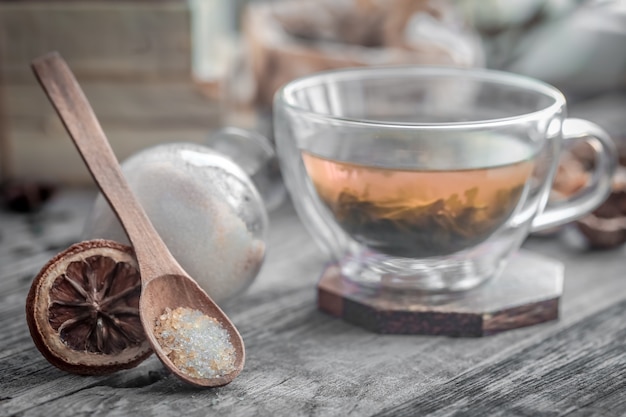 木製の背景に生姜とお茶の透明で香りの良いカップのある静物