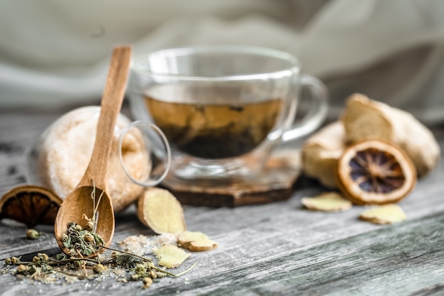 still life with transparent and fragrant Cup of tea with ginger on wooden background