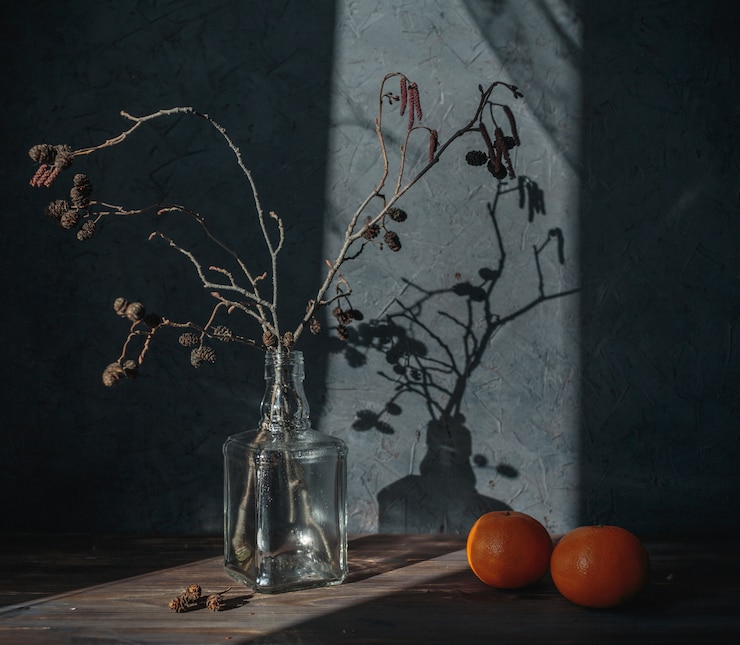 Photo still life with a vase and tangerines in the sunlight