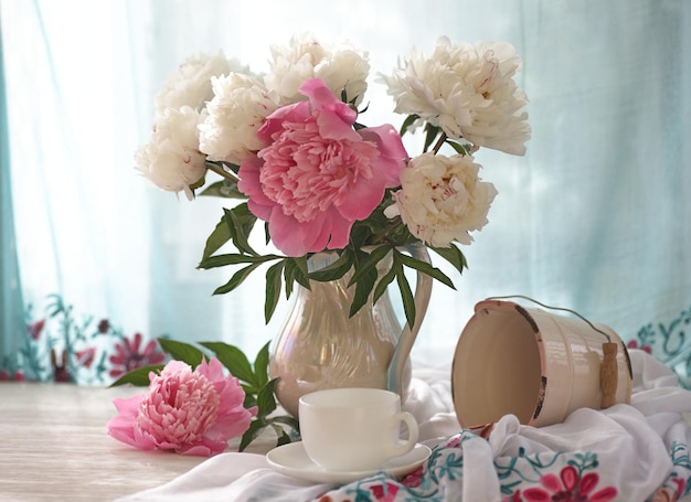 Still life with white and pink peonies in a white vase