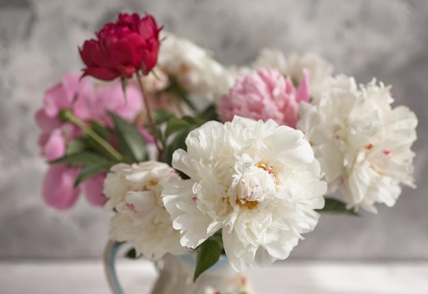 Natura morta con peonie bianche e rosa in vaso bianco