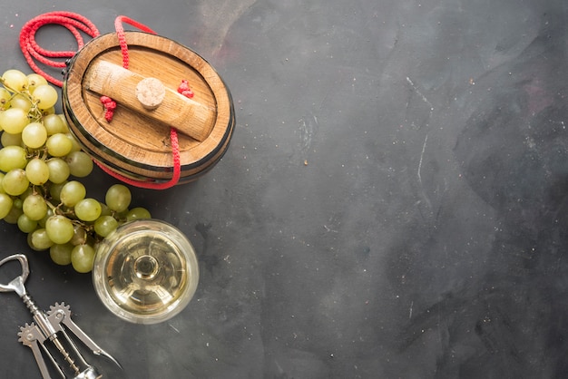 The still life with white wine, glass and old barrel