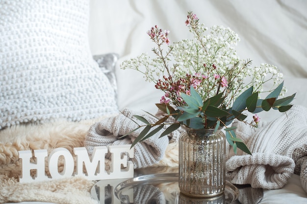 Photo still life with a wooden inscription home and a vase of flowers