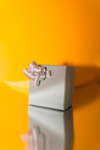 Still life of wrapped present box in gray with a curly ribbon