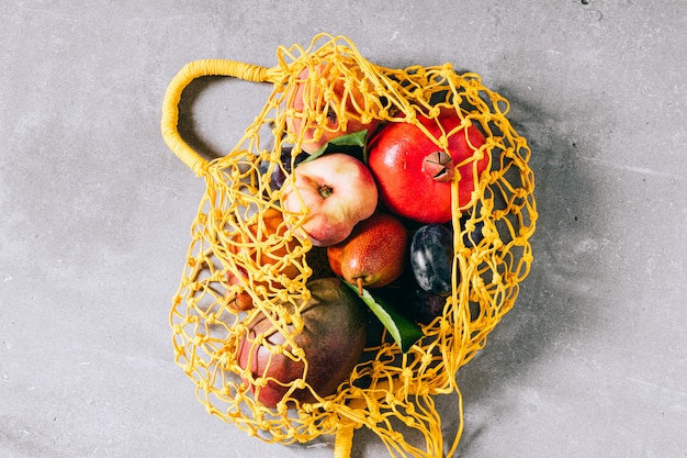 Photo still life of yellow biodegradable shopping bag with raw fruit