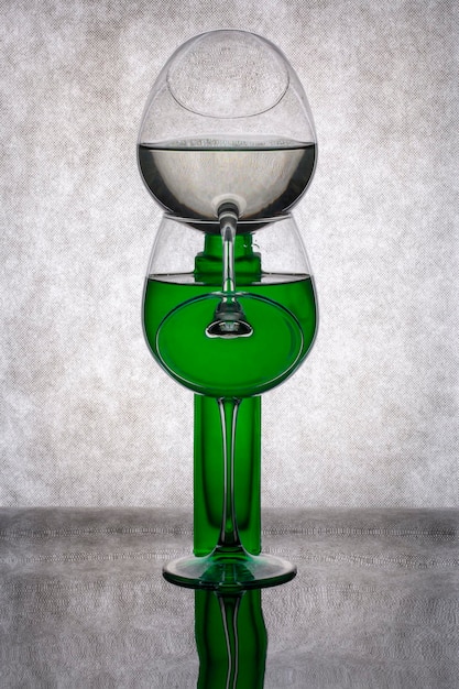 Stille natuur met een groene vaas en een glas vloeistof