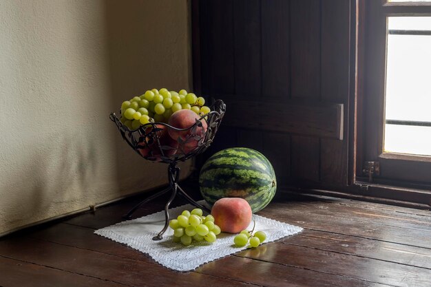 Stille natuur met fruit in een vaas op de vensterbank