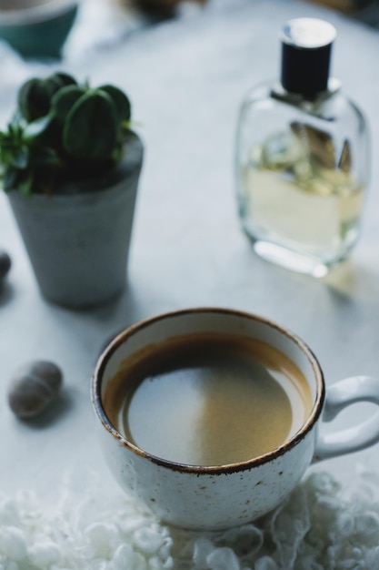 Stilleven details kopje koffie plant pot glazen op witte achtergrond in de woonkamer Gezellige ochtend concept Koffiepauze op de werkplek Selectieve aandacht