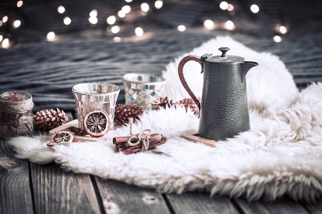 Foto stilleven huisdecoraties met een theepot op een houten achtergrond in het interieur van de kamer met licht op de achtergrond, een vakantieconcept