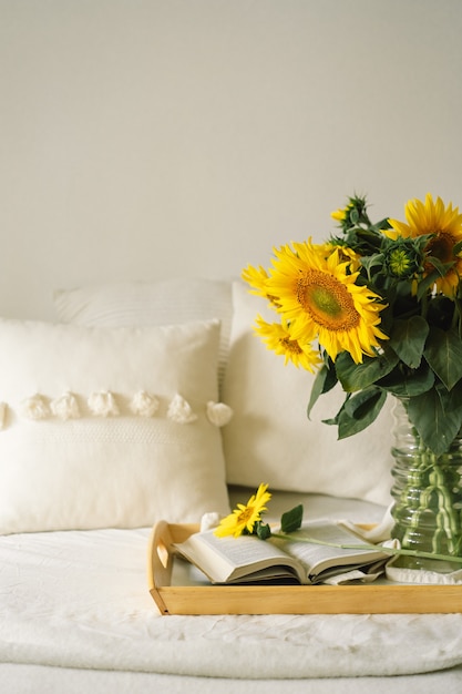 Stilleven in huisbinnenland van woonkamer. Zonnebloemen, koffie en open boek. Lees, rust