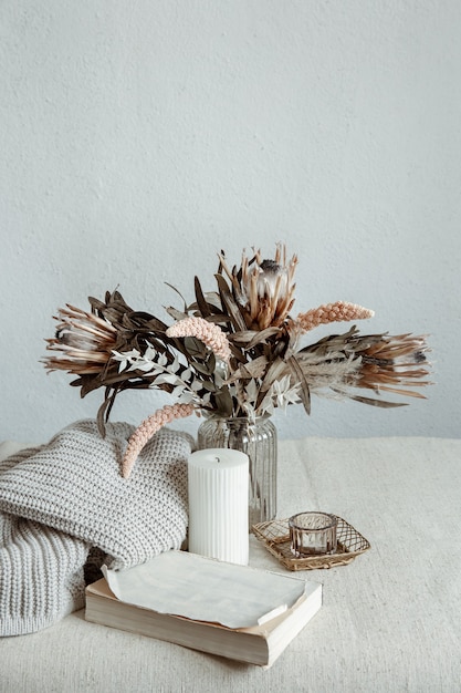 Foto stilleven in scandinavische stijl met een boeket bloemen, een gebreid element en decoratieve details