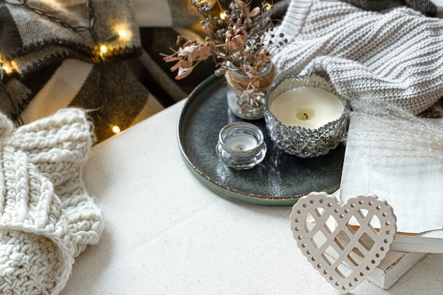 Stilleven met decoratief hart, boeken en kaarsen in kandelaars. Het concept van Valentijnsdag en huisdecor.