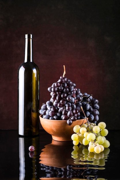 Stilleven met druiven en een fles wijn