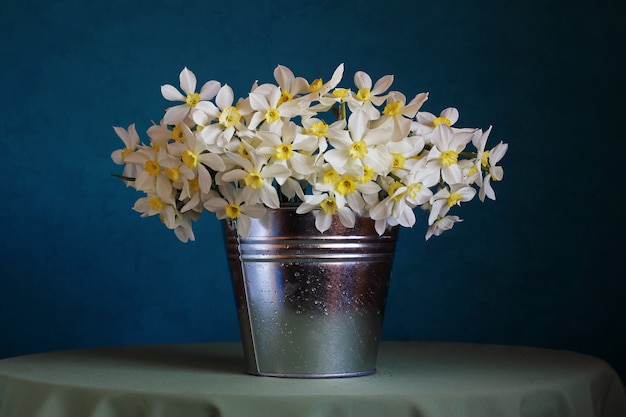 Stilleven met een boeket van narcissen in een emmer