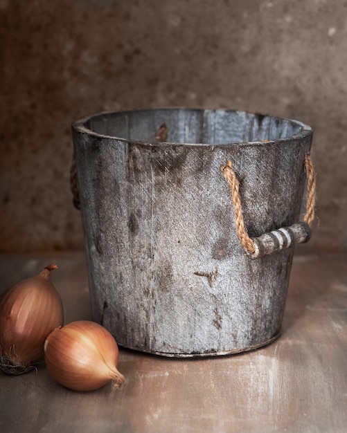 Stilleven met een houten plantenbak en uienkoppen op een houten ongelijk geschilderde tafelclose-up