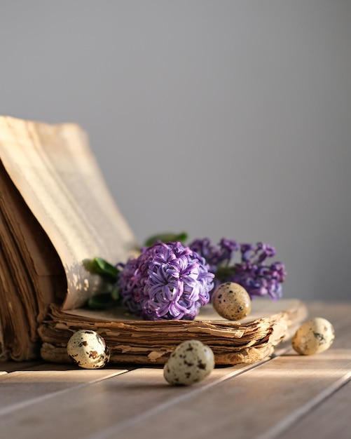 Stilleven met een oud boek bloemen en kwarteleitjes lente Pasen stilleven