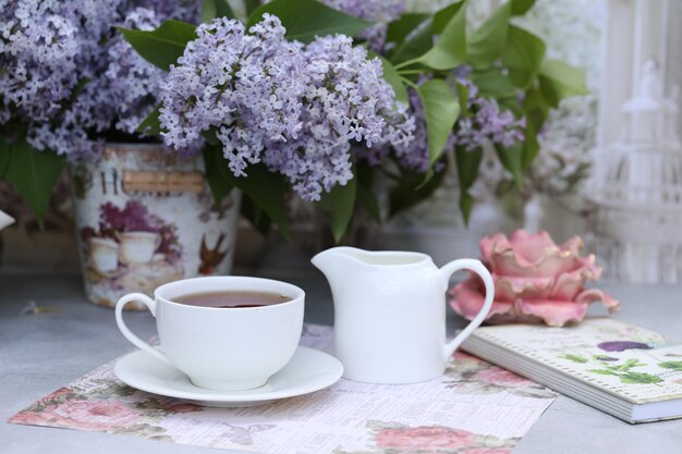 Stilleven met kopje thee in de ochtend en lila bloemen