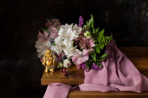 Stilleven met lachende Boeddha bloemen en rokende wierook