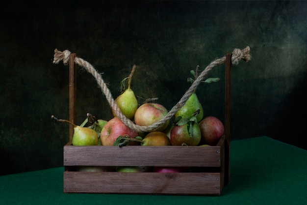 Stilleven met rijpe appels en peren in een houten kist