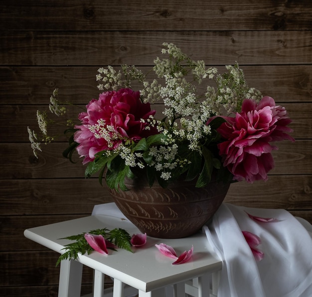 Foto stilleven met roze pioenrozen en wilde bloemen