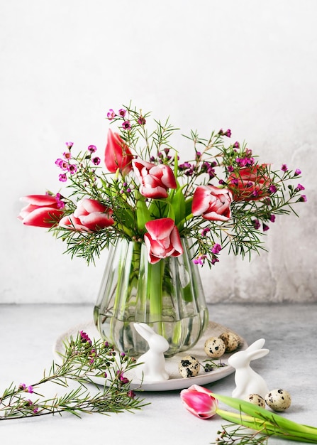 Stilleven met roze, witte tulpen en paarse wasbloembloemen in de oude vintage glazen vaas