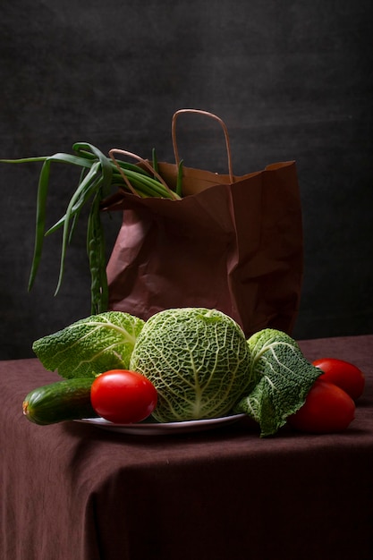 Stilleven met savooiekool, komkommer, rode tomaten en ui