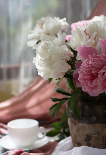 Stilleven met witte en roze pioenrozen in een oude vaas