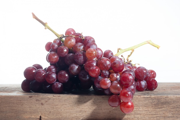 Stilleven van druivenfruit gezet op oude houten, witte achtergrond