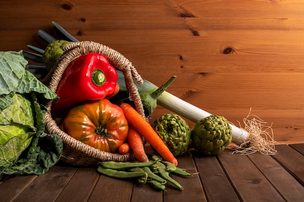 Foto stilleven van groenten uit de tuin op houten tafel en zwarte achtergrond