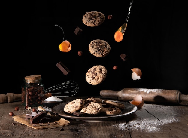 Stilleven van koekjeskoekjes en vliegende eieren Bereiding van koekjes op een donkere rustieke achtergrond