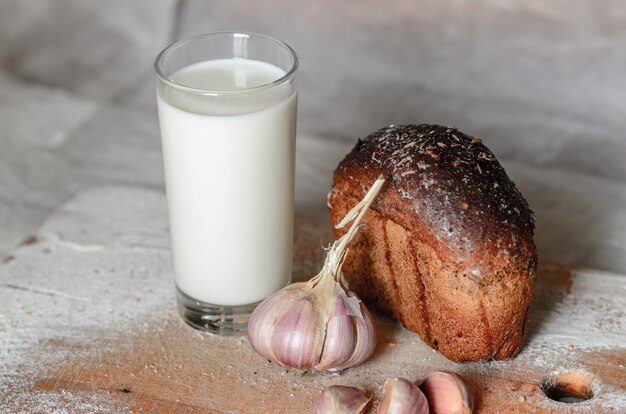 Stilleven van melk, brood en knoflook.