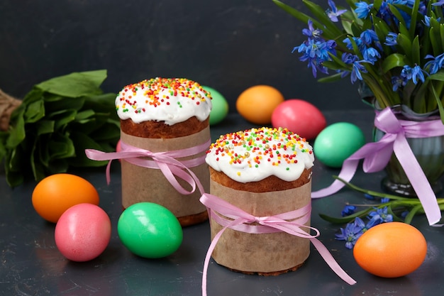 Stilleven van Pasen-cakes, beschilderde eieren en bossneeuwklokjes op donkere achtergrond