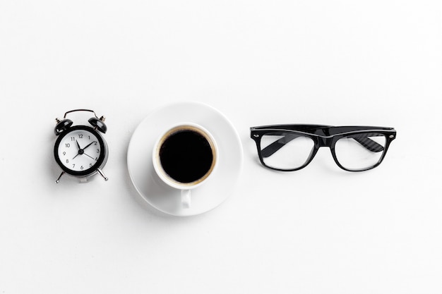 Stilleven, vintage wekker en koffiekopje op witte tafel