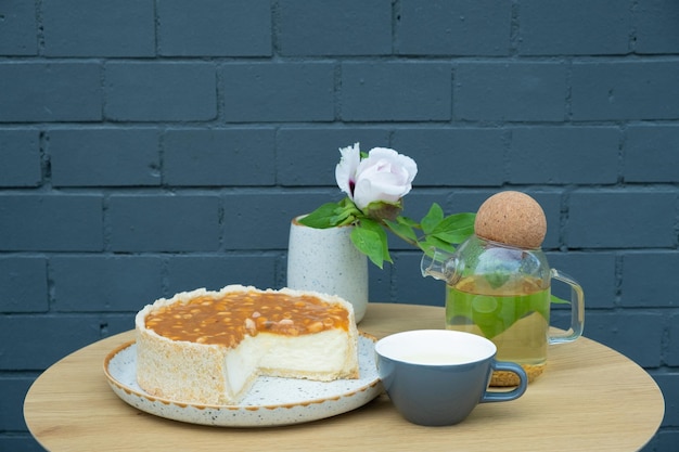 Stilleven voedselsamenstelling met thee en kwarktaart op een ronde tafel Dessert in een café