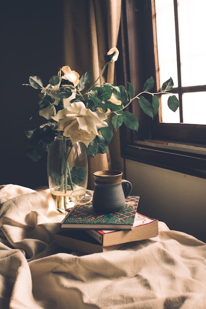 Foto stillevensamenstelling van theekopje, boeken en bloemen