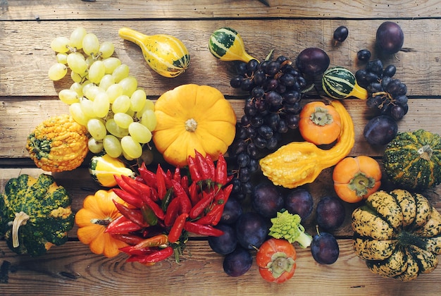 Stilllife background with fresh organic fruits and vegetables Assortment of ripe plums grapes