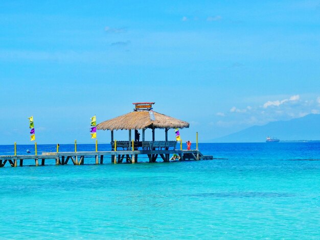 Stilt house over sea against sky