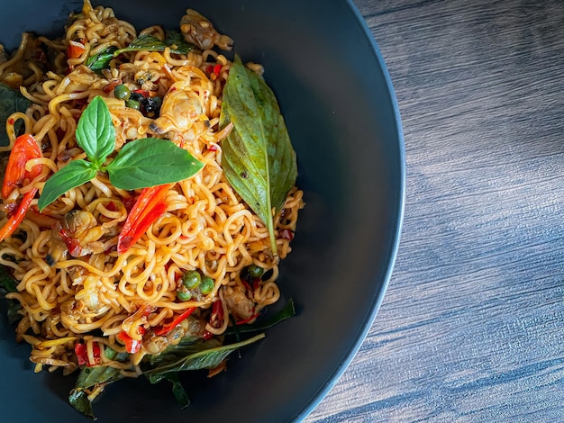 Photo stir fire spicy noodle with clam on the table