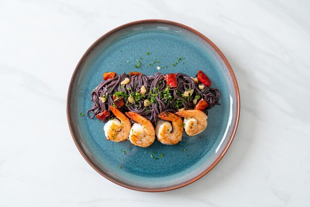 Stir-fried black spaghetti with garlic and shrimps on\
plate