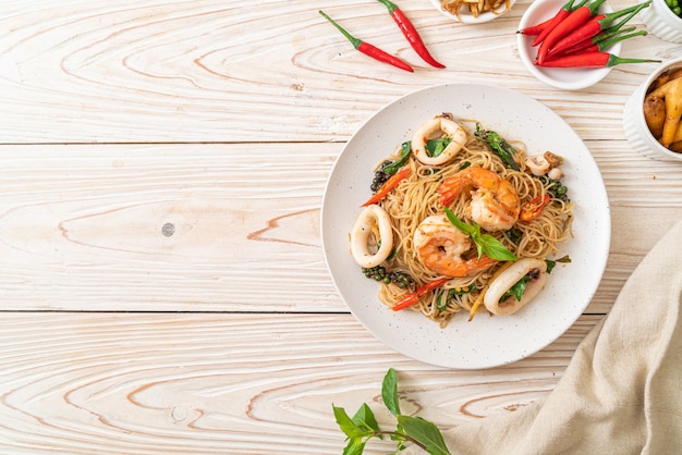 Mescolare, spaghetti cinesi fritti con basilico, peperoncino, gamberetti e calamari, stile di cibo asiatico