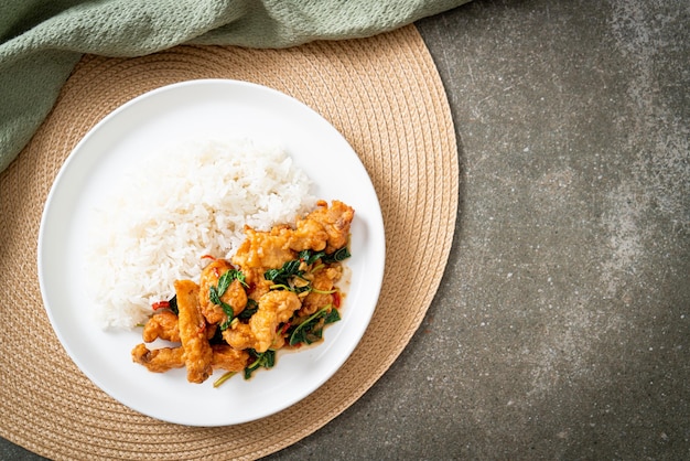 stir-fried fried fish with basil and chili in thai style topped on rice - Asian food style