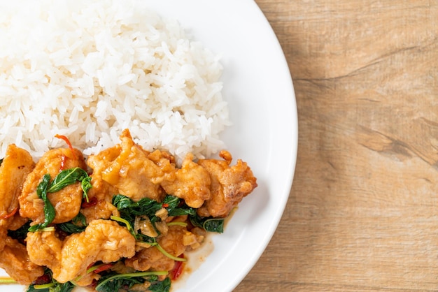 stir-fried fried fish with basil and chili in thai style topped on rice - Asian food style