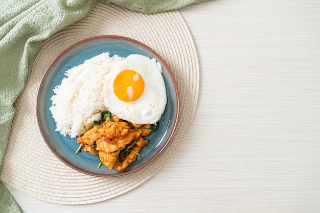 stir-fried fried fish with basil and fried egg topped on rice - Asian food style