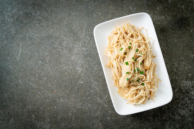 stir-fried golden needle mushroom with butter on white plate