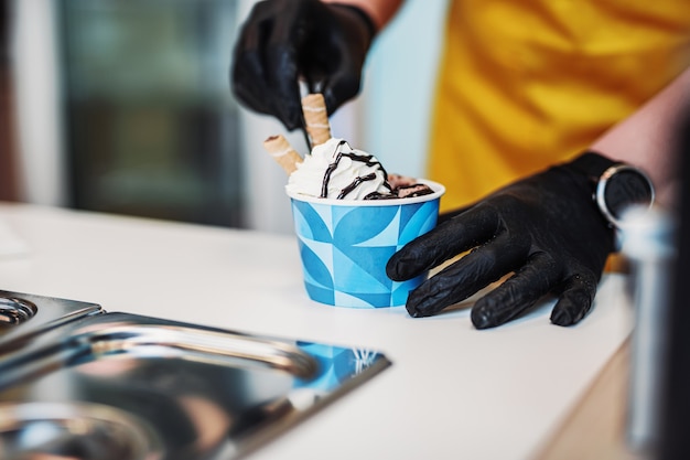 Жареные булочки с мороженым в морозильной камере. Десерт из мороженого ручной работы на холодной тарелке. Машина для жареного мороженого со стальной охлаждающей сковородой.