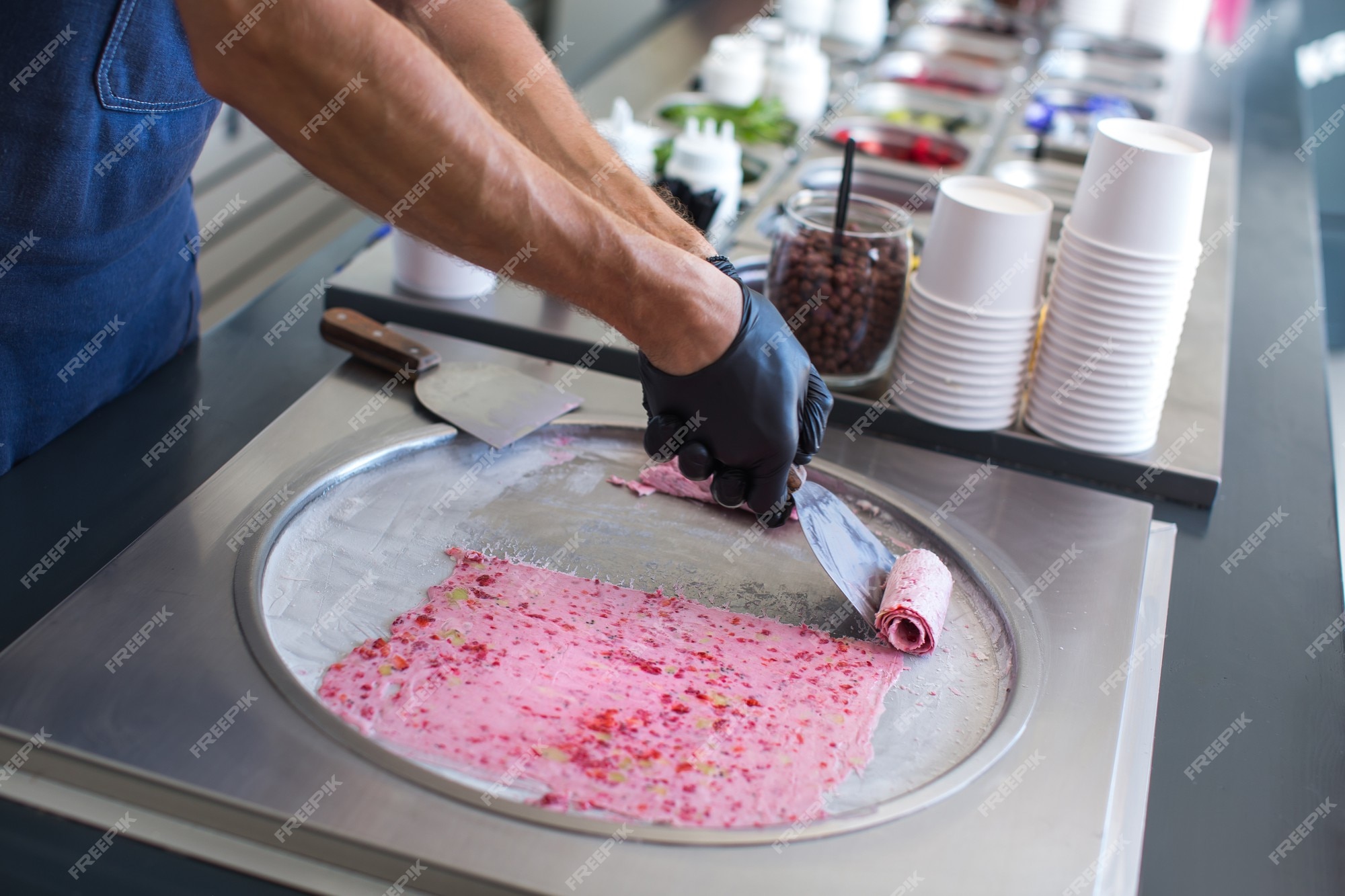 Premium Photo  Stir-fried ice cream rolls at freeze pan. rolled ice cream,  hand made ice cream dessert. fried ice cream machine with steel chilled pan.