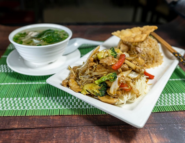 Stir-fried noodles with chicken and vegetables with chaufa rice. Wantan soup. Peruvian Chinese food.